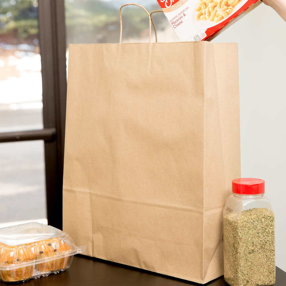 Image of 14in x 10in x 15.75in Duro Bag® Dubl Life® 70# Brown Super Rotyal Paper Bags with gusseed flat bottom and paper twist handle on a kitchen table