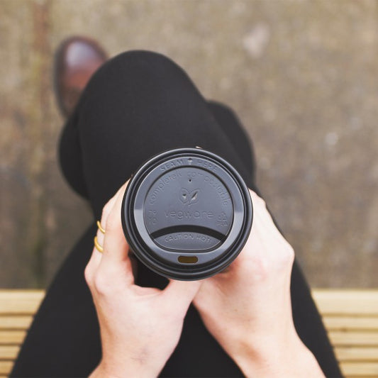 A CPLA hot cup lid. Fits 79-Series cups. A lid for hot coffees or teas to go. Made from CPLA, sleek black color, embossed with Vegware messaging. Award-winning quality by Vegware, made from plants. 